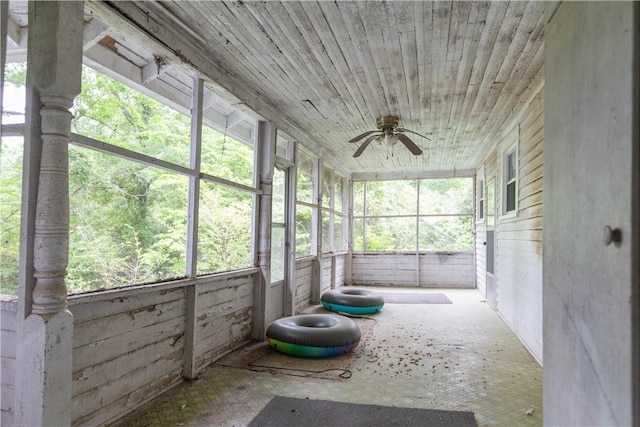 unfurnished sunroom featuring a ceiling fan