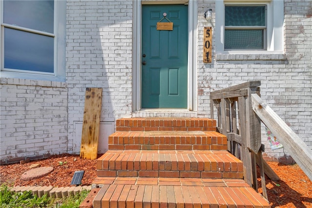 doorway to property featuring brick siding