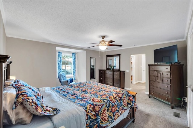 bedroom featuring light colored carpet, a textured ceiling, ornamental molding, ceiling fan, and baseboards