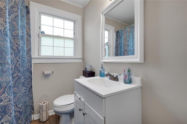 bathroom with vanity, crown molding, plenty of natural light, toilet, and wood finished floors