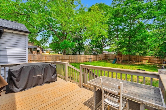 wooden terrace featuring a playground and outdoor dining space