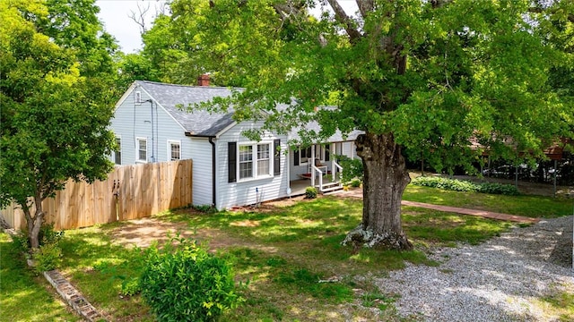 view of front of house featuring a chimney and a shingled roof