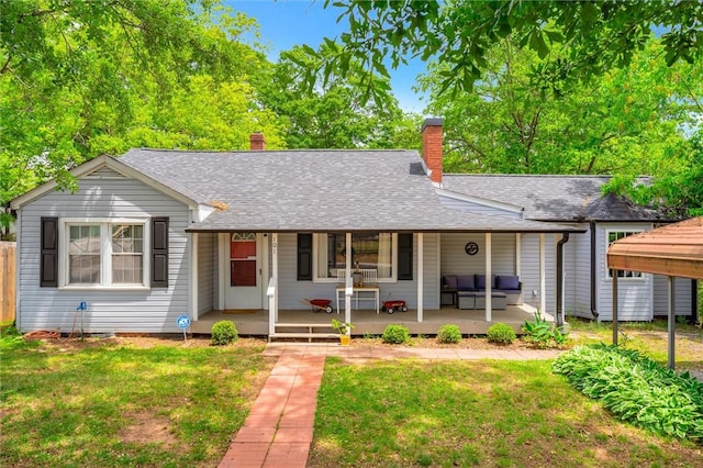 ranch-style home with a chimney, roof with shingles, an outdoor living space, and covered porch