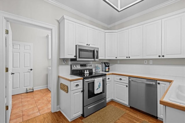 110 Red Maple Cir, Easley, SC 29642 - kitchen with stainless steel appliances, light countertops, white cabinets, crown molding, and light wood-style floors
