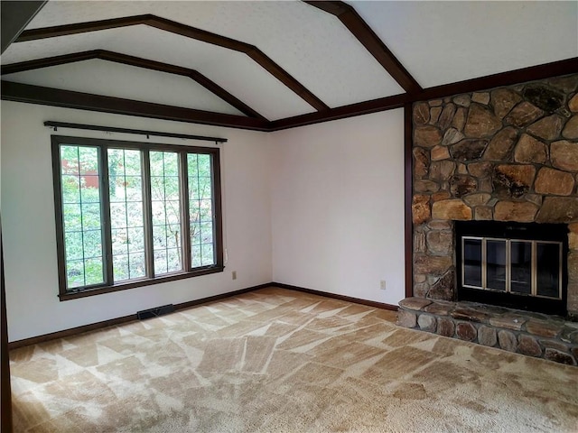unfurnished living room featuring healthy amount of natural light, vaulted ceiling, carpet flooring, baseboards, and a fireplace