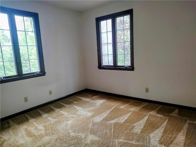 unfurnished room with healthy amount of natural light and carpet