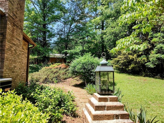 view of green lawn featuring central AC