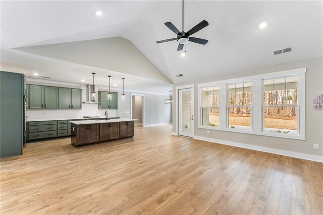 327 Thompson Rd, Taylors, SC 29687 - kitchen featuring green cabinetry, wall chimney range hood, open floor plan, light countertops, and a sink