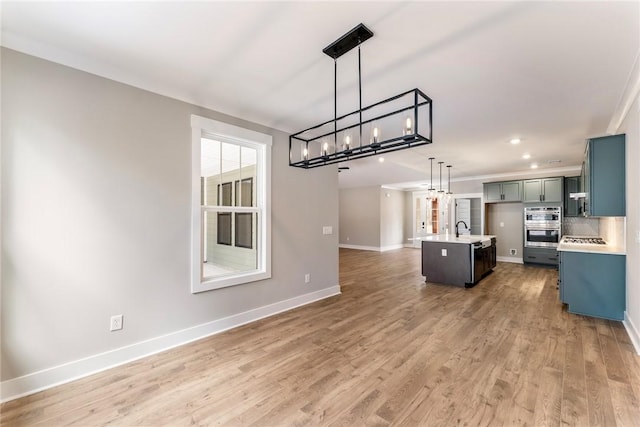 327 Thompson Rd, Taylors, SC 29687 - kitchen featuring open floor plan, baseboards, light wood-style floors, a chandelier, and a sink
