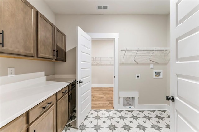 327 Thompson Rd, Taylors, SC 29687 - laundry area featuring electric dryer hookup, washer hookup, light floors, cabinet space, and baseboards