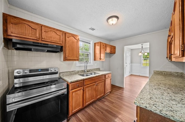 1922 Dobbins Ave, Anderson, SC 29625 - kitchen with stainless steel electric stove, under cabinet range hood, a sink, wood finished floors, and brown cabinetry