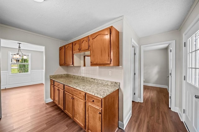 1922 Dobbins Ave, Anderson, SC 29625 - kitchen with dark wood-style flooring, a textured ceiling, light countertops, brown cabinetry, and tasteful backsplash