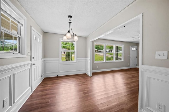 1922 Dobbins Ave, Anderson, SC 29625 - unfurnished dining area featuring a textured ceiling, a wainscoted wall, dark wood-type flooring, and a decorative wall