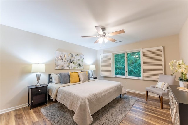 bedroom featuring baseboards, light wood-style flooring, and a ceiling fan