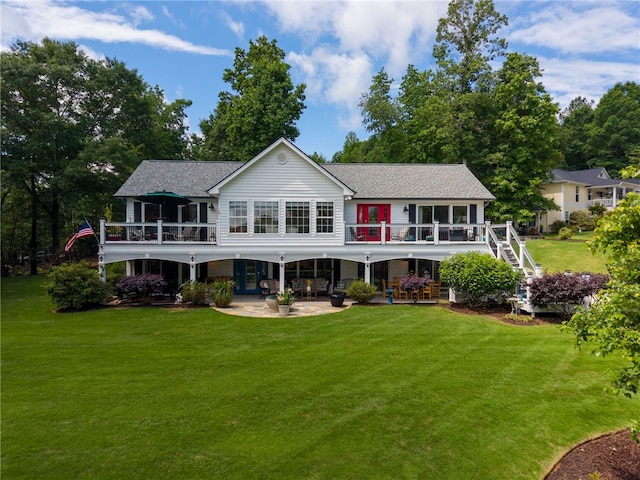 back of house with a patio area, a yard, roof with shingles, and a deck