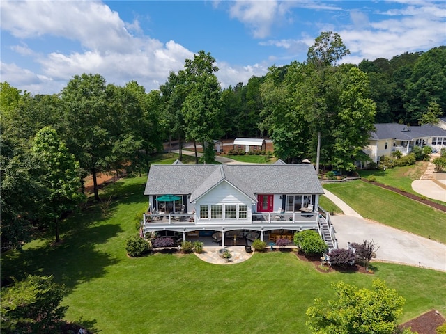 rear view of property with a deck, a yard, and stairway