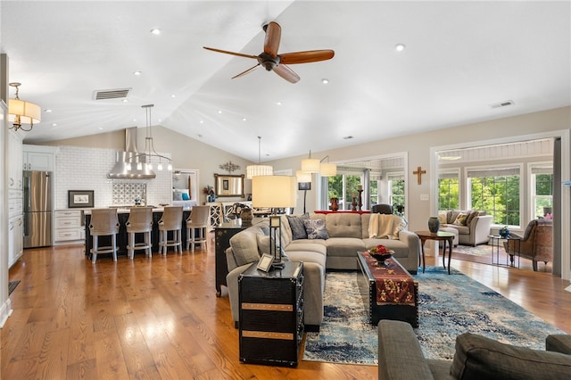 living area with vaulted ceiling, a ceiling fan, light wood-style flooring, and recessed lighting