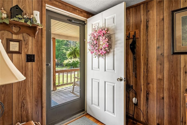 entryway with wooden walls and a textured ceiling