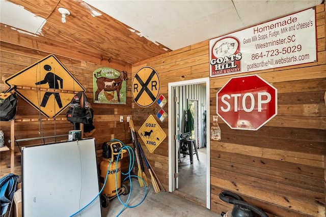 miscellaneous room with wooden walls and concrete floors