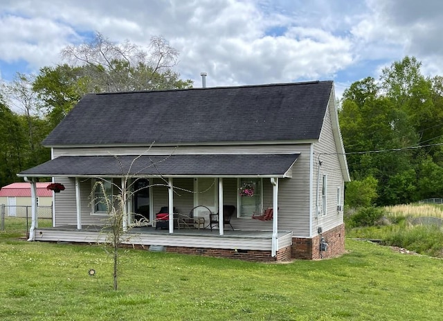 back of property featuring a porch, roof with shingles, a lawn, and crawl space