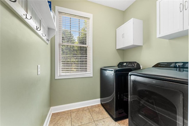 laundry room with independent washer and dryer, baseboards, cabinet space, and light tile patterned floors