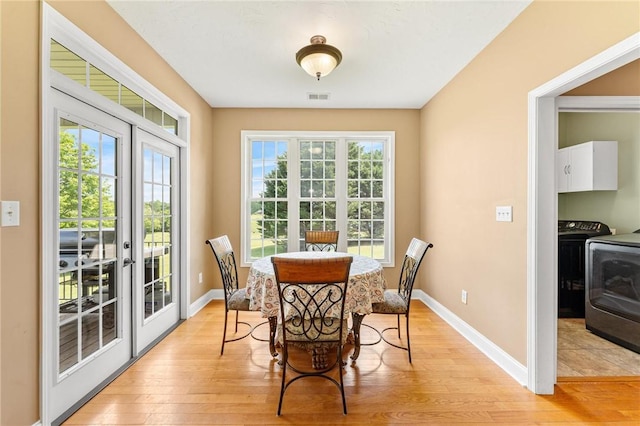 dining room with french doors, light wood finished floors, and baseboards