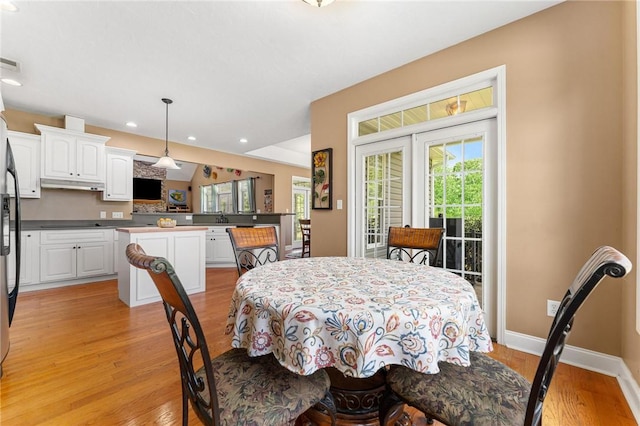 dining room with recessed lighting, light wood finished floors, and baseboards