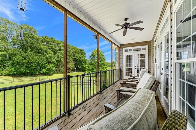 sunroom / solarium featuring french doors and ceiling fan
