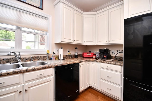 kitchen with black appliances, a sink, and white cabinets
