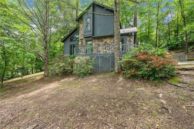 view of home's exterior featuring a wooden deck and stone siding