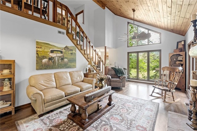 living area featuring wood finished floors, healthy amount of natural light, wooden ceiling, stairway, and high vaulted ceiling