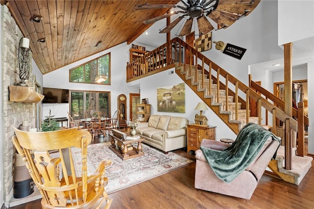 living area featuring high vaulted ceiling, ceiling fan, stairs, ornate columns, and wood ceiling