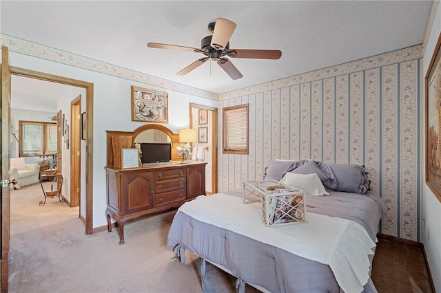carpeted bedroom with baseboards, wallpapered walls, and a ceiling fan