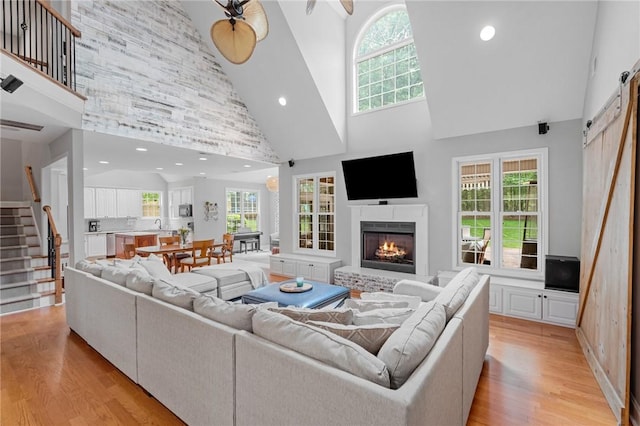 103 Crepe Myrtle Ln, Anderson, SC 29625 - living area featuring high vaulted ceiling, a barn door, stairs, light wood finished floors, and a lit fireplace