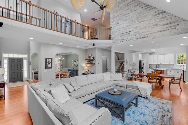 103 Crepe Myrtle Ln, Anderson, SC 29625 - living room with a high ceiling, arched walkways, ceiling fan, stairway, and light wood-style flooring