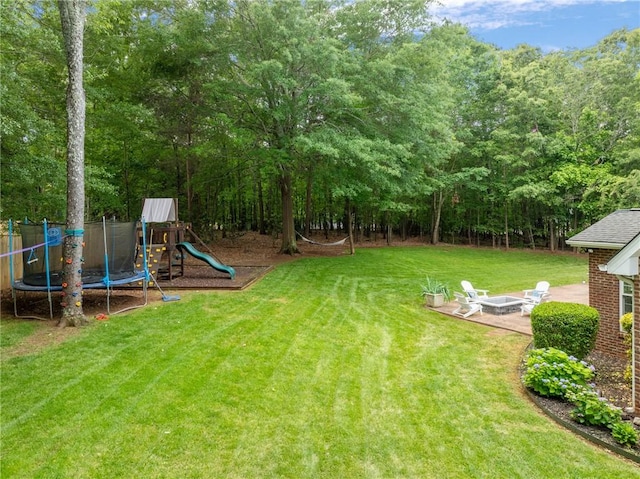 103 Crepe Myrtle Ln, Anderson, SC 29625 - view of grassy yard featuring an outdoor fire pit, a trampoline, a playground, and a patio area