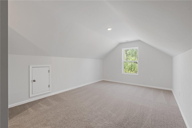 additional living space featuring baseboards, lofted ceiling, and carpet