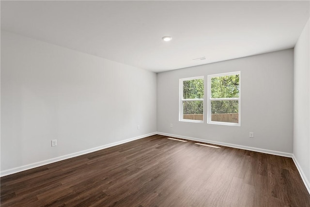 unfurnished room featuring dark wood finished floors and baseboards