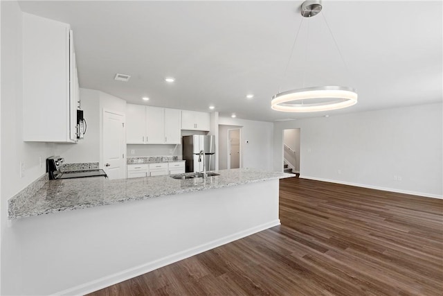 kitchen featuring stainless steel appliances, a sink, dark wood finished floors, recessed lighting, and white cabinetry