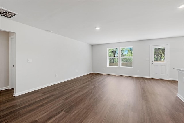 empty room with dark wood-style flooring, baseboards, and recessed lighting