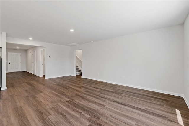 spare room featuring stairs, recessed lighting, baseboards, and dark wood-style floors