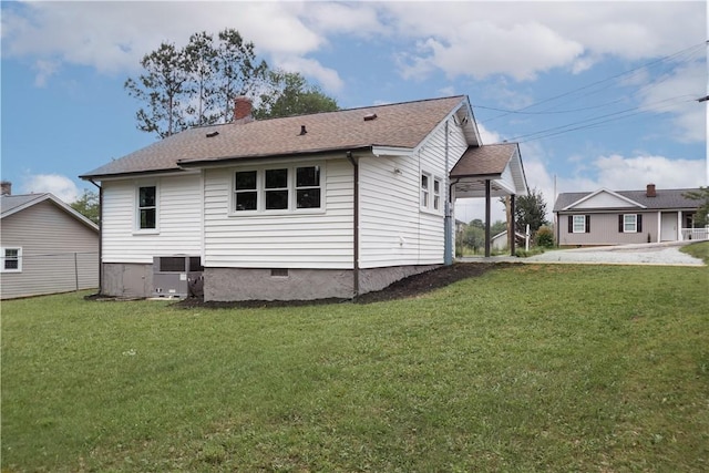 rear view of house featuring a lawn, a chimney, crawl space, central air condition unit, and a shingled roof