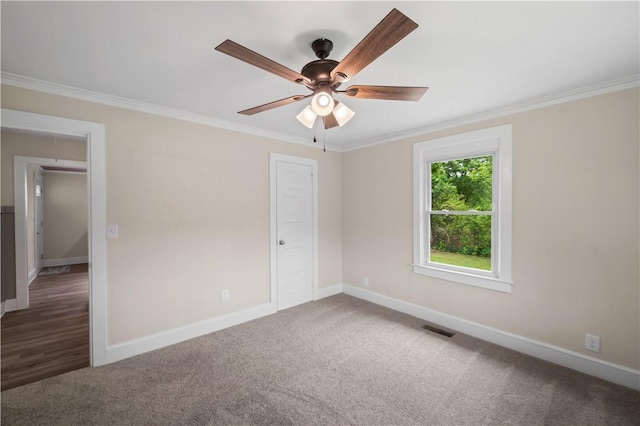 empty room featuring crown molding, a ceiling fan, baseboards, and carpet