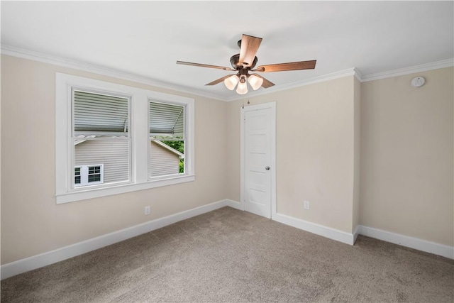 carpeted spare room featuring ornamental molding, ceiling fan, and baseboards