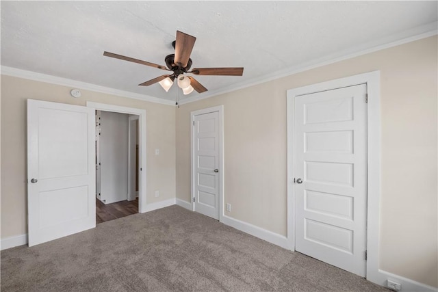 unfurnished bedroom featuring carpet, crown molding, baseboards, and a ceiling fan