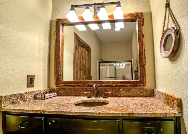 bathroom featuring a textured wall and vanity