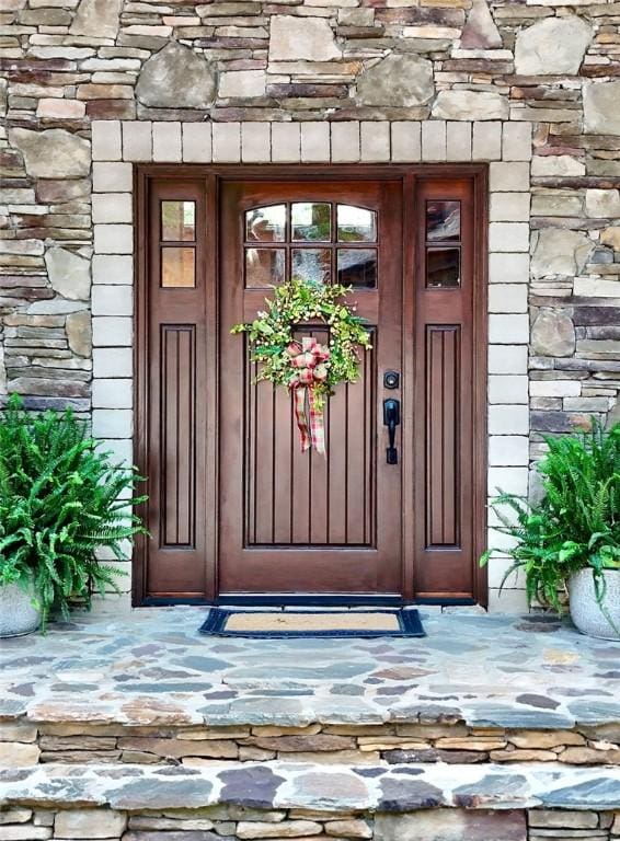view of exterior entry featuring stone siding