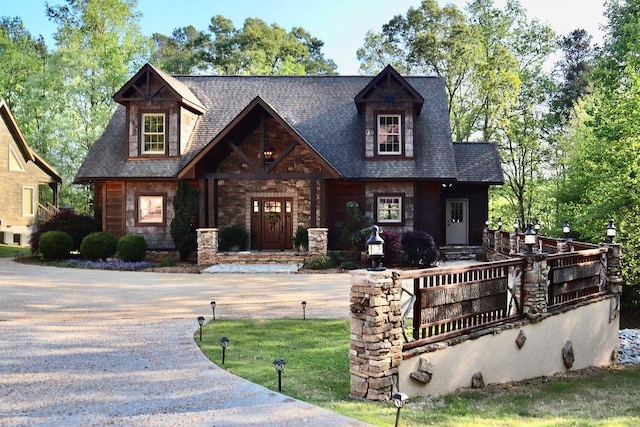view of front of property with stone siding and a shingled roof