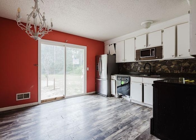 4709 Mcdonald Ave, West Columbia, SC 29172 - kitchen featuring stainless steel fridge, a sink, a textured ceiling, dark countertops, and black dishwasher