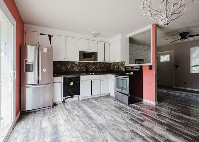 4709 Mcdonald Ave, West Columbia, SC 29172 - kitchen featuring appliances with stainless steel finishes, tasteful backsplash, dark countertops, white cabinetry, and light wood-type flooring